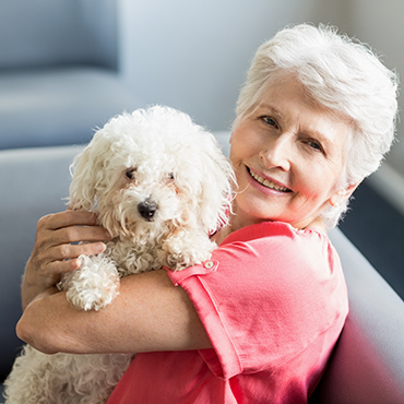 senior woman holding curly haired dog