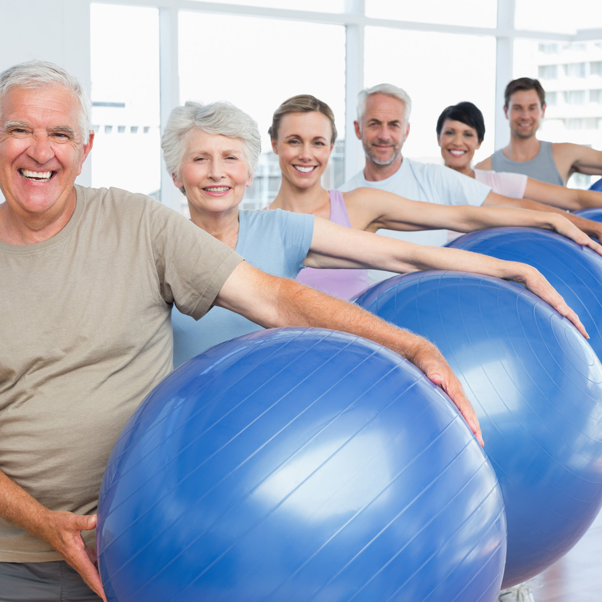 group of seniors and middle aged adults holding exercise balls