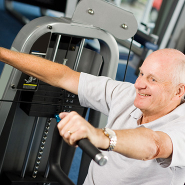 Senior man working on gym equipment