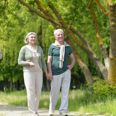 senior couple holding hands while taking a walk outdoors