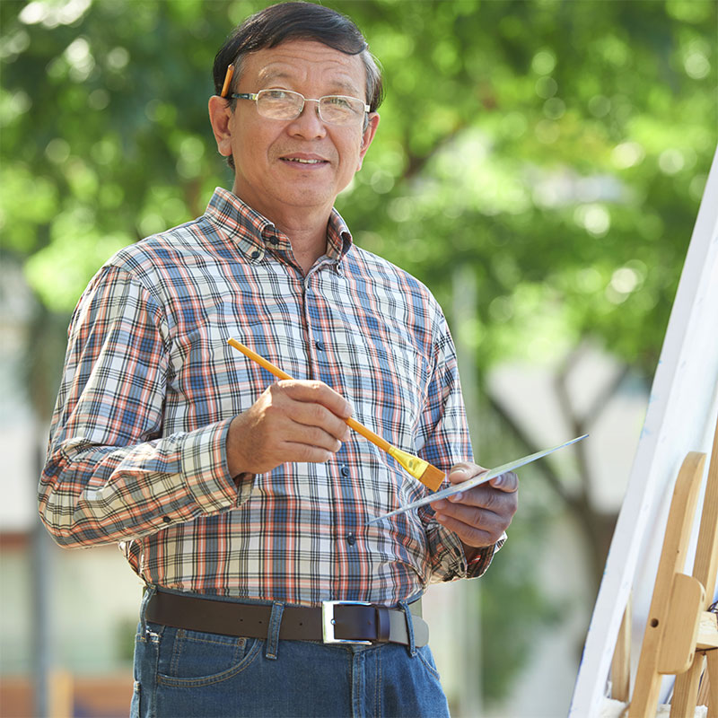 Senior man outdoors painting
