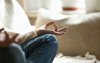 Close up of senior woman meditating on couch in living room