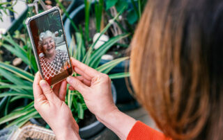 Woman looking at smartphone on video call with mother